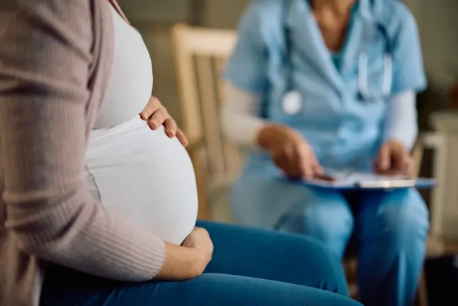 o femeie insarcinata care discuta cu medicul