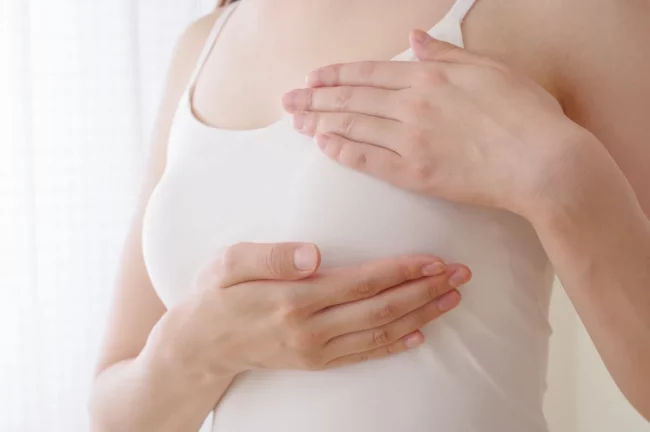 femeie care isi palpeaza sanii