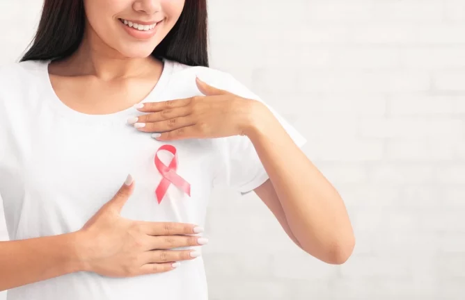 Femeie care poartă în piept simbolul cancerului de sân