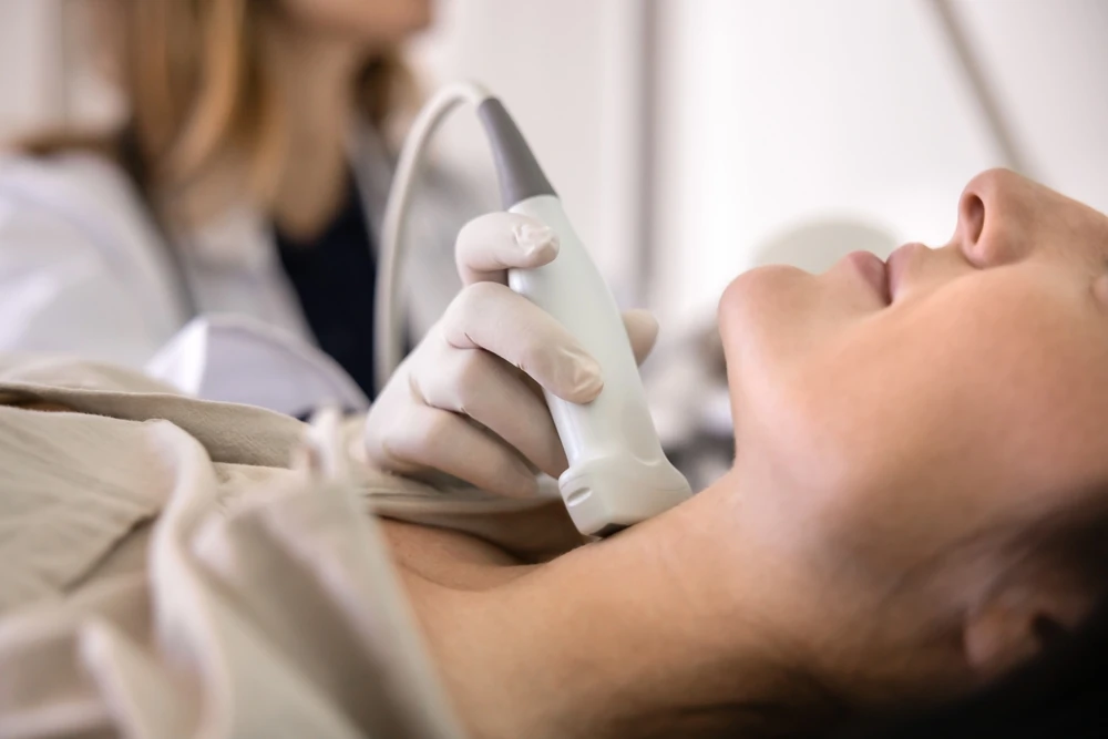 Medic endocrinolog care realizează o ecografie tiroidiană unei paciente